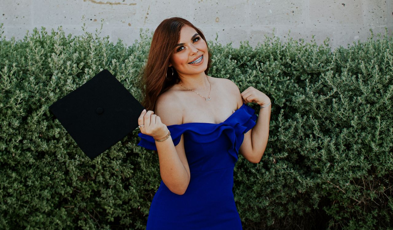 Senior portrait sitting in front of circular wall opening